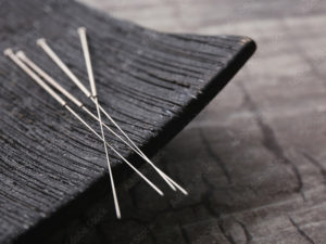 photo of acupuncture needles on black dish