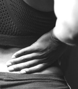 a woman holds her lower back in pain